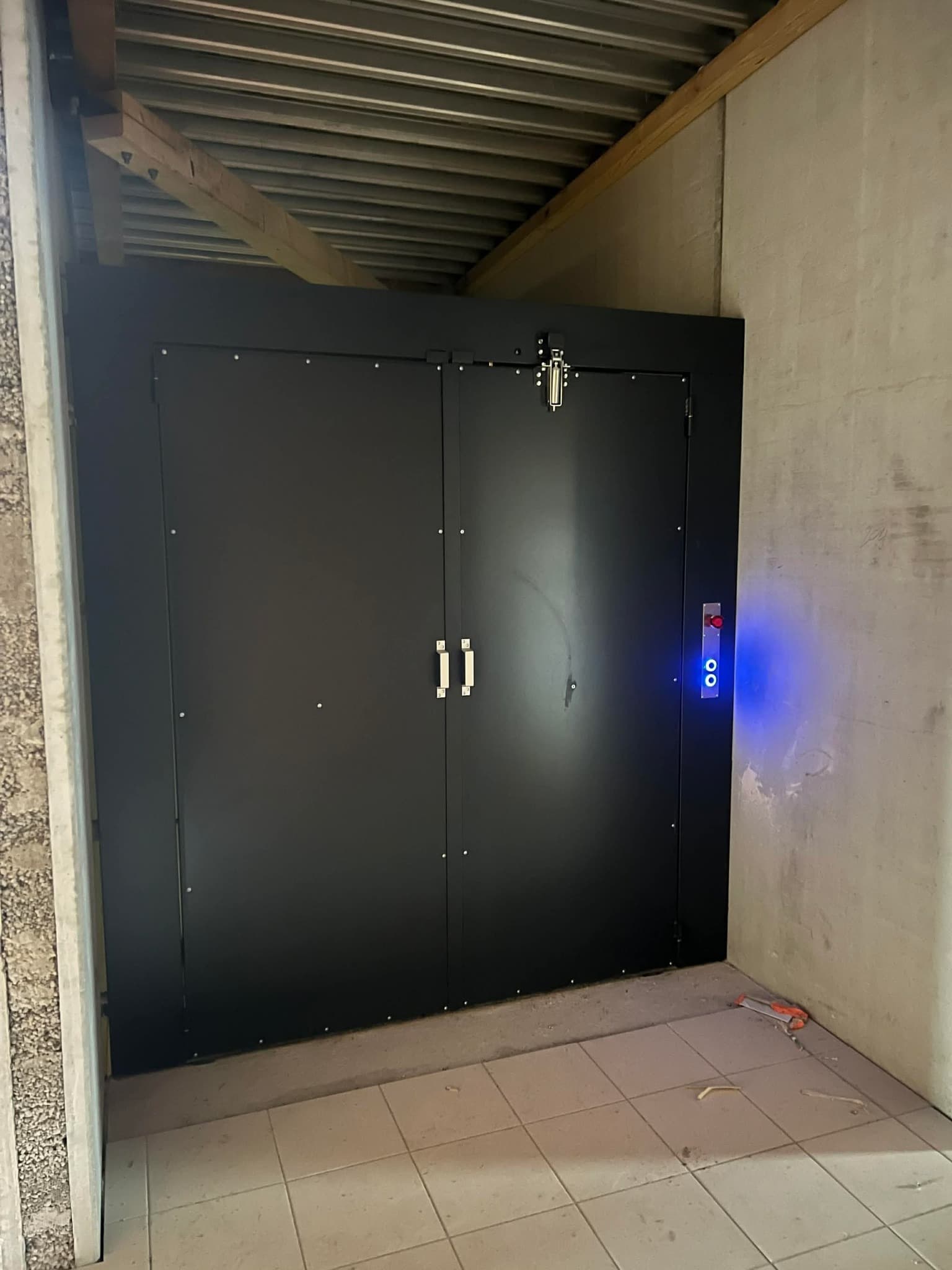 Monte-charge noir avec portes fermées.